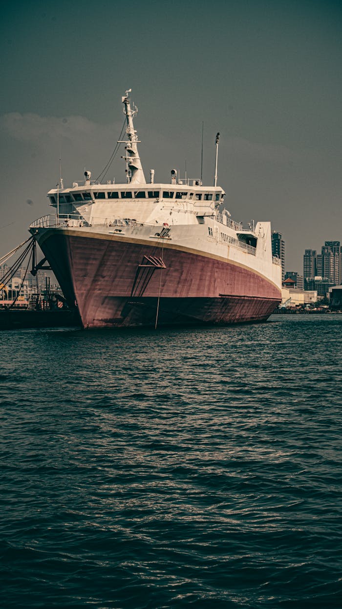 A large ship docked at Kaohsiung Harbor, Taiwan, under a moody sky, showcasing maritime architecture.